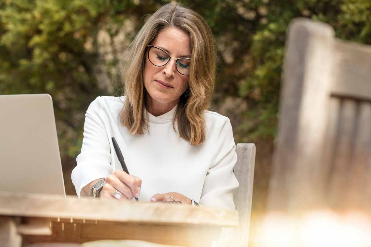 woman sitting at a table writing